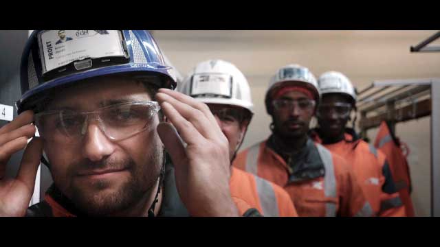 Quatre compagnons en tenue de chantier mettent leur lunette pour une vidéo bande annonce