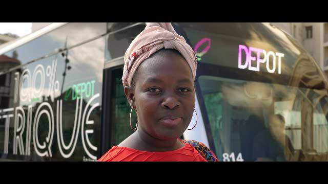 Portrait d'une femme qui sourit devant le bus de Biarritz pour la vidéo corporate d'Eiffage Route