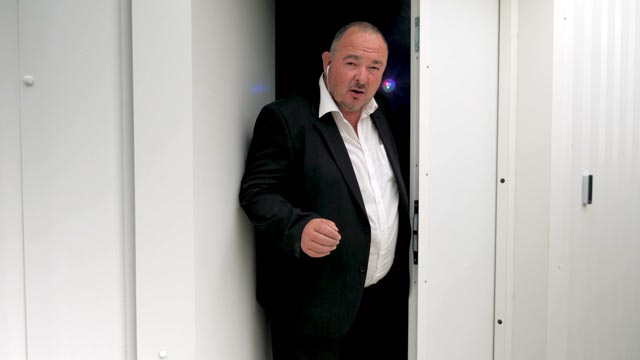 Un préventeur en costume à l'entrée d'un local pour une série de film sécurité