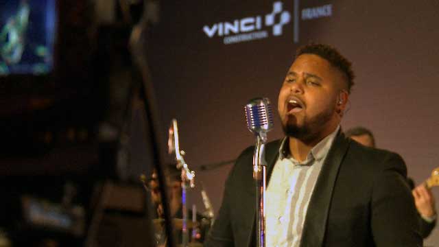 Un chanteur chante devant un micro, image extrait d'une vidéo évènementielle