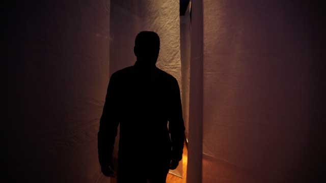 L'artiste Maurice Pefura marche entre les panneaux de son oeuvre Continuum filmé pour la vidéo d'exposition