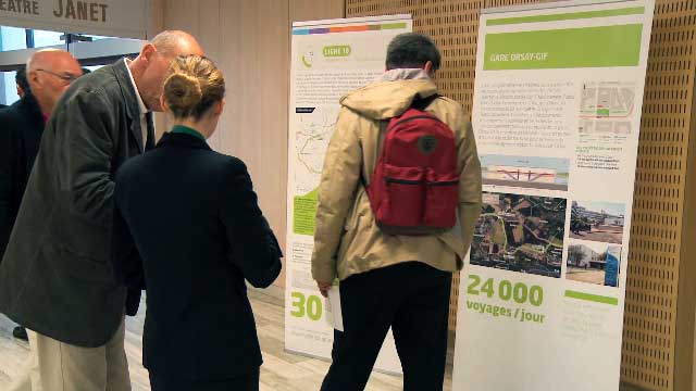 Dans un évènement, des personnes regardent une PLV