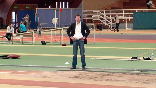 Un homme pose au milieu d'une salle de sport de l'INSEP pour une série vidéo d'interview